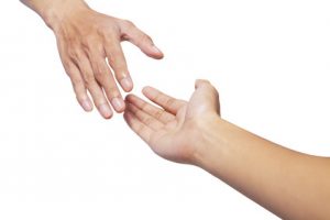 Helping hands, male hand takes young female hand